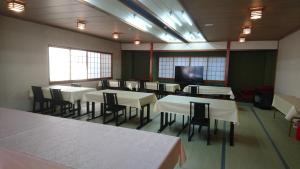 a dining room with tables and chairs and a flat screen tv at Resort Inn Fujihashi in Fujikawaguchiko