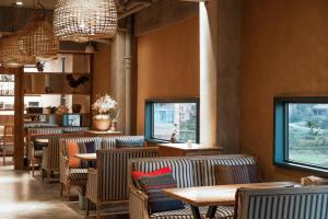 um restaurante com cadeiras, mesas e janelas em The Twelve Manor•Terraces Lodge em Yuanyang