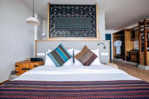 um quarto com uma grande cama branca com almofadas em The Twelve Manor•Terraces Lodge em Yuanyang