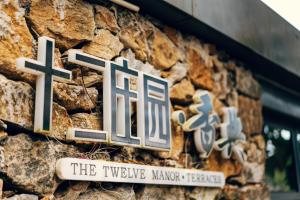 um sinal na lateral de um edifício de pedra em The Twelve Manor•Terraces Lodge em Yuanyang