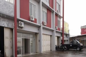 a red and white building with a truck parked outside at Super OYO 2183 Cibeureum Residence in Bandung