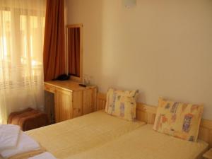 A bed or beds in a room at Family Hotel Ilinden