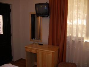 Habitación con TV en la parte superior de un tocador en Family Hotel Ilinden, en Shipkovo