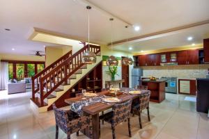 cocina y comedor con mesa y sillas en Tiga Samudra Villa, en Canggu