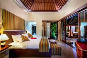 een slaapkamer met een groot bed en een balkon bij Tiga Samudra Villa in Canggu +15 foto's