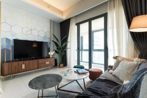 een woonkamer met een bank en een tv bij TriBeCa 2bedroom 3min walk to bukit bintang 2 rooftop pool in Kuala Lumpur