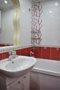 a bathroom with a sink and a tub and a mirror at 2 комнатные апартаменты на Габдуллина 46а in Kokshetau
