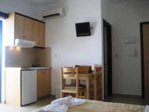 a kitchen with a table and a small kitchen with a refrigerator at Yiorgos Studios in Palaiochora