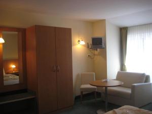 a hotel room with a cabinet and a small table at Strandhotel Mirow in Mirow