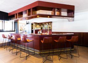 a dining room with a bar and chairs at Bastion Hotel Rotterdam Alexander in Rotterdam