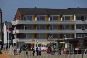 ヘルゴラントにあるHotel Quisisana & Appartements Quisiの建物の外に立っている人々のグループ