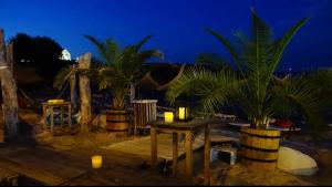 um pátio com palmeiras e velas à noite em Хотел Paradise em Carevo