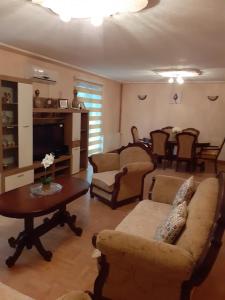 a living room with a couch and chairs and a table at Sweet Holiday Home in Hadžići