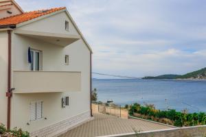 a white building with a view of the water at Apartments Rogulj in Rogoznica