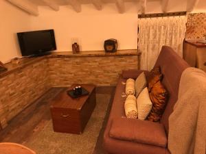 salon z brązową kanapą i telewizorem w obiekcie Nuestra Casita de Papel w mieście Cehegín