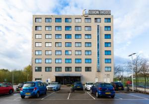 a building with cars parked in a parking lot at Bastion Hotel Rotterdam Alexander in Rotterdam