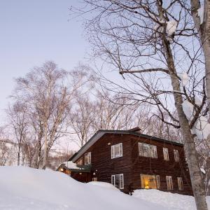 Lodge 401 Niseko Annupuri في نيسيكو: بيت خشبي في الثلج اشجار