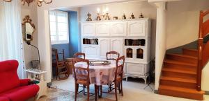 a dining room with a table and a cabinet at La Dimanche in Reuil-sur-Marne