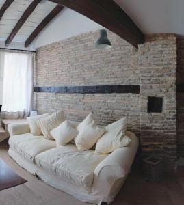 una sala de estar con un sofá blanco contra una pared de ladrillo en Atico Estafeta en Pamplona