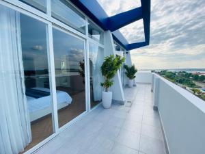 a balcony with a bed and some windows at Hung Phuoc Hotel in Bến Cát