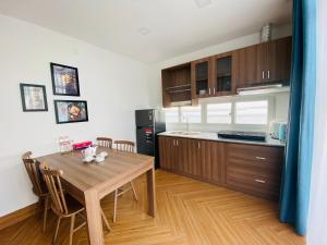 a kitchen with a wooden table and a dining room at Hung Phuoc Hotel in Bến Cát