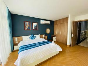 a bedroom with a large bed with a blue wall at Hung Phuoc Hotel in Bến Cát
