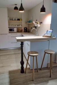 a kitchen with a counter and two stools in it at Atico Estafeta in Pamplona