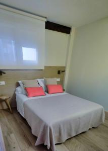 パンプローナにあるAtico Estafetaのベッドルーム1室(大型ベッド1台、赤い枕2つ付)