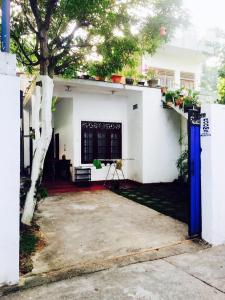 a white house with a tree in the yard at City Bay House in Weligama +26 photos