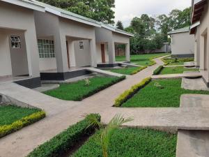 un patio de un edificio con césped y plantas en Delight Lodge en Blantyre