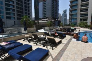 a group of lounge chairs next to a swimming pool at Princess Tower highest world Penthouse floor 86! in Dubai