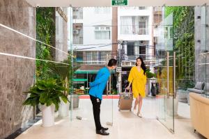 a man and a woman standing in a lobby at Nalicas Nha Trang Hotel in Nha Trang