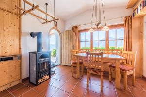 a kitchen and dining room with a wood stove at Almliesl STVE-510 in Sankt Veit im Pongau