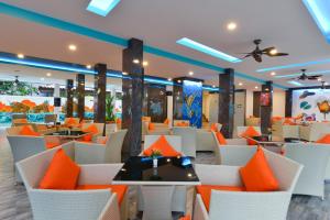 restauracja z pomarańczowymi i białymi krzesłami i stołami w obiekcie T2 Ao Nang Krabi w Aonang Beach