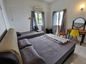salon z 2 łóżkami i kanapą w obiekcie Beachfront Unit at Seri Bulan , Pantai Teluk Kemang w mieście Kampong Tanah Merah