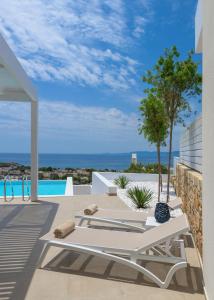 patio z białym stołem i widokiem na ocean w obiekcie Villa Mimosa in Pefkos (Lindos area) w Líndos