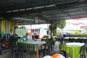 a group of tables and chairs in a patio at Singgahan Keluarga Jitu in Jitra