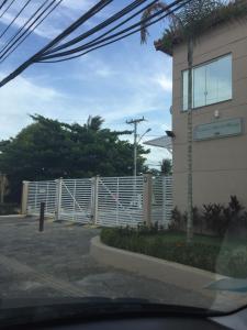 a fence in a parking lot next to a building at Linda casa na Praia do Flamengo in Salvador