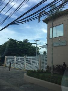 una cerca blanca frente a un edificio en Linda casa na Praia do Flamengo, en Salvador