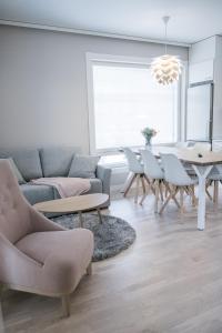 uma sala de estar com um sofá, uma mesa e cadeiras em Santasport Apartment Hotel em Rovaniemi