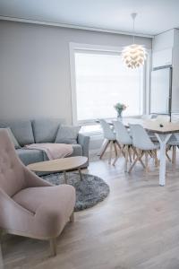 een woonkamer met een bank en een tafel en stoelen bij Santasport Apartment Hotel in Rovaniemi