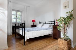 a bedroom with a black bed and a window at Willa Ludwinia in Gdynia