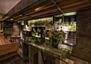 eine Bar in einem Restaurant mit Pflanzen an der Wand in der Unterkunft Nostoi in Jakarta