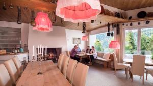 un groupe de personnes assises à une table dans une salle à manger dans l'établissement Hotel Haus am Waldrand, à Flims