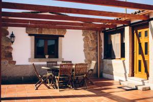 a patio with a table and chairs and a yellow door at Casa Rural O Rozo in Tui