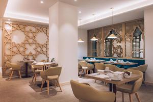 a restaurant with tables and chairs and a wall at Iberostar Selection Marbella Coral Beach in Marbella