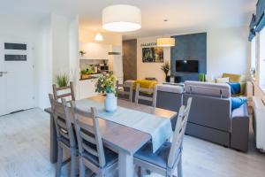 a dining room and living room with a table and chairs at Apartamenty Izerskie - ul. Cicha 13D-E in Świeradów-Zdrój