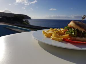 a sandwich on a white plate on a beach at Lofts Azul Pastel in Horta
