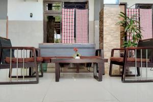 SumenepにあるRedDoorz @ Hotel Surabaya Sumenepのテーブル、椅子2脚、テーブル、ベンチ