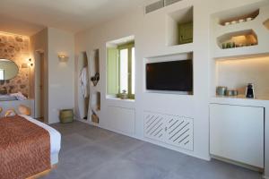a bedroom with a bed and a flat screen tv at Aeon Suites - Adults Only in Pirgos